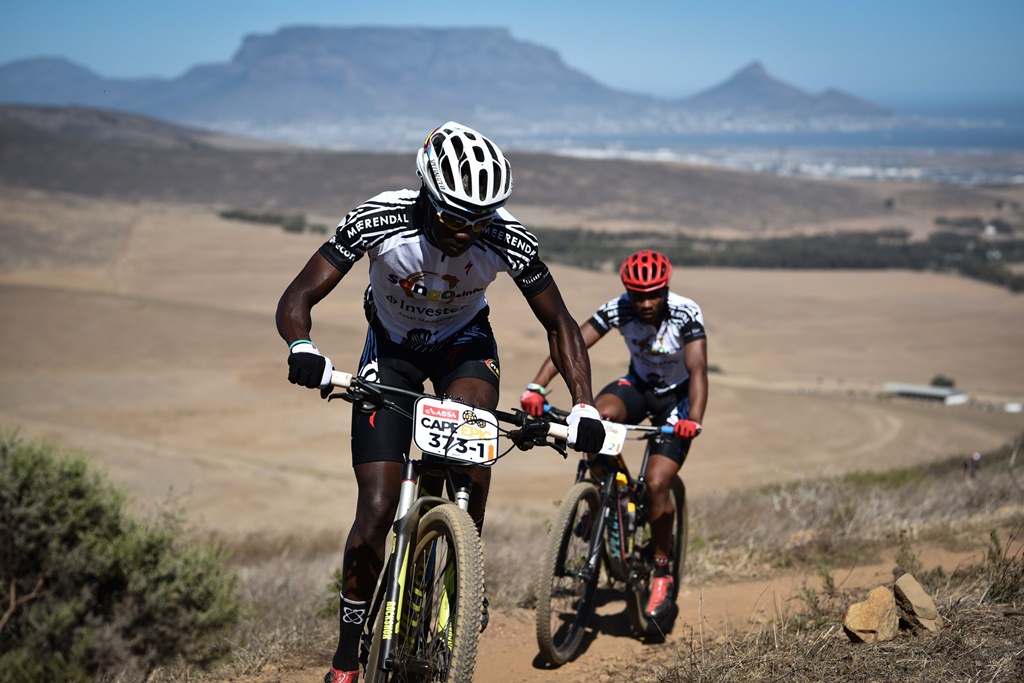 Thando Klaas leads teammate Lorenzo Leroux up a climb during the Prologue of the 2017 Absa Cape Epic. Photo by Sportograf.